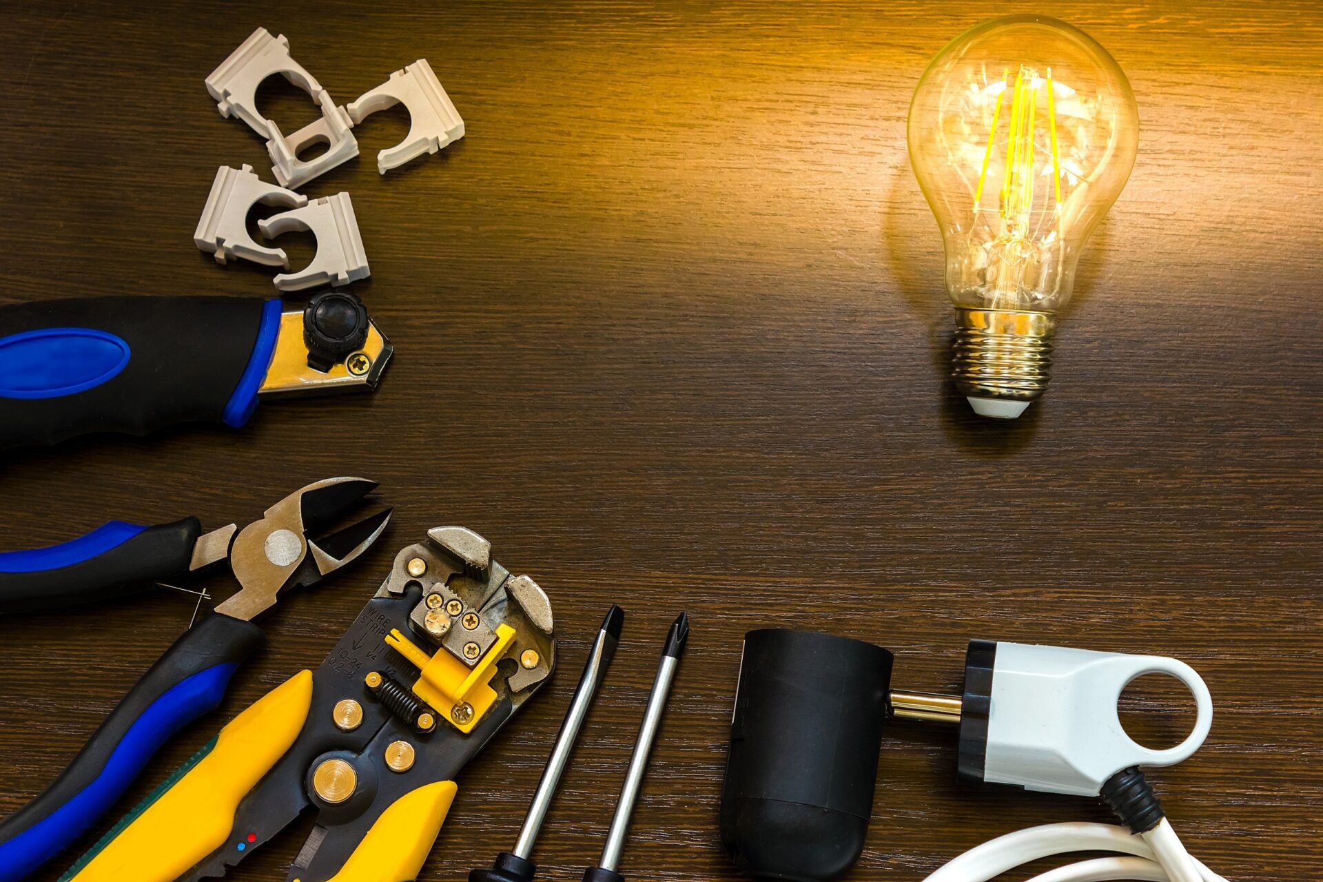 burning light bulb and socket and other electrician tools are on the table